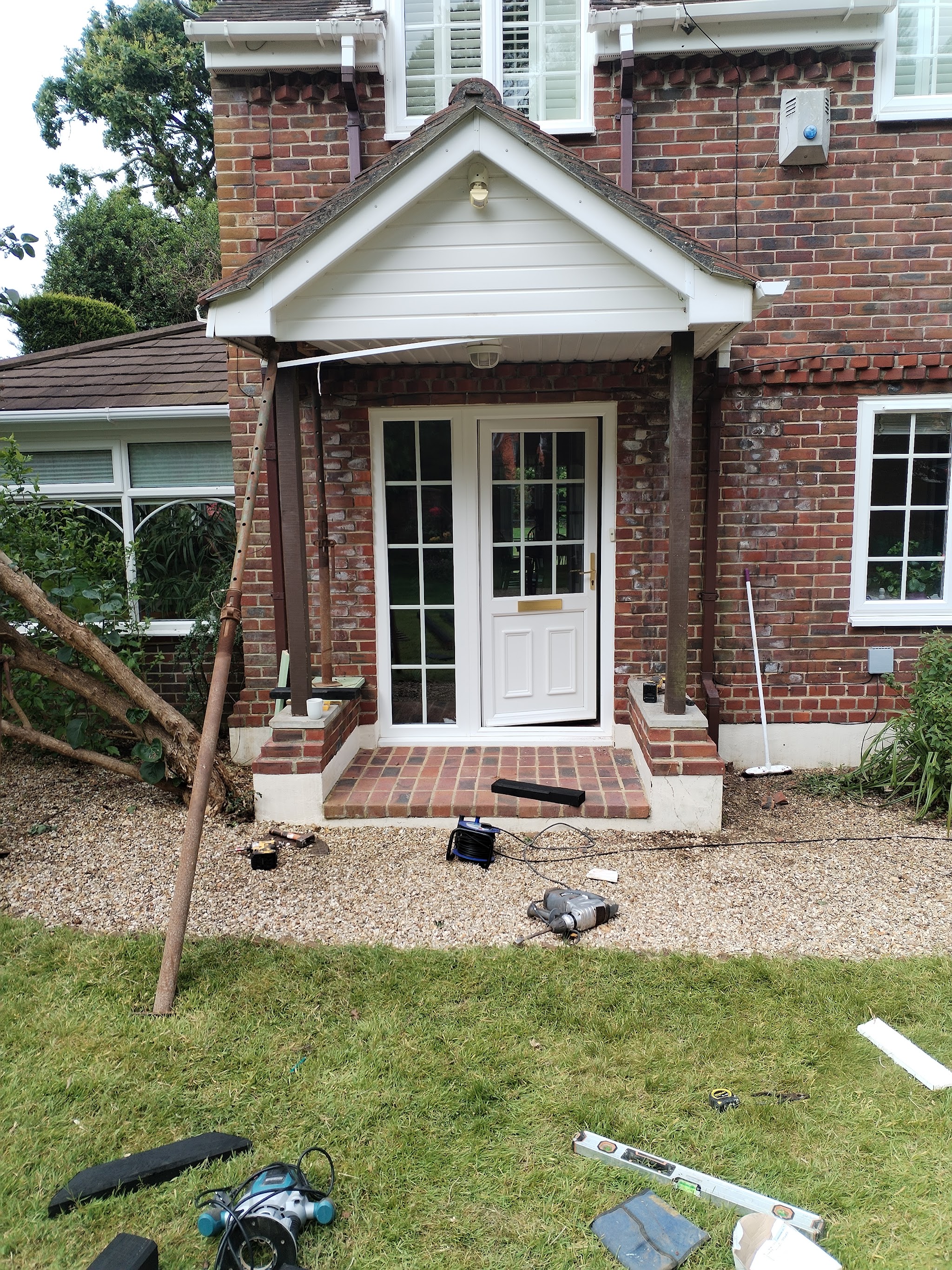 A new porch canopy going up over French doors on a red-brick house