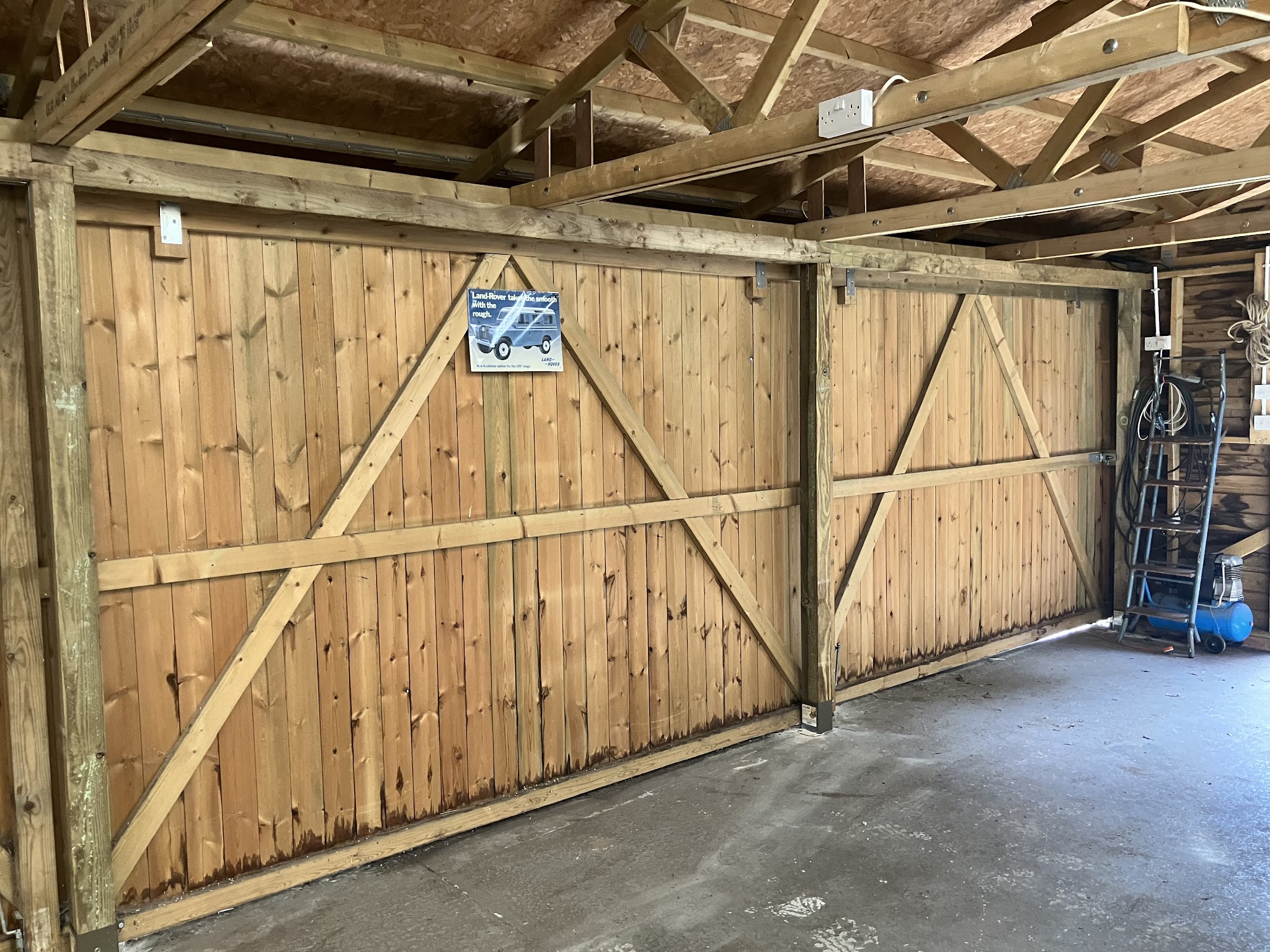 New twin timber garage doors, ledged and braced, seen from inside the garage